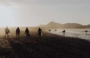 SPAIN - LANZAROTE - FAMARA BEACH AT SUNSET WITH ITS SURFERS photographe plateau de cinéma Lyon, photographe plateau cinéma Auvergne Rhône Alpes, belles photos de plateau tournage cinéma, tournage film que la nuit vienne de billie dumas cannes 2022